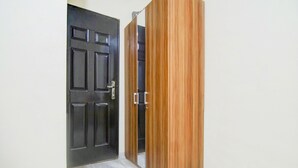 Une pièce avec une porte noire fermée et une armoire en bois.