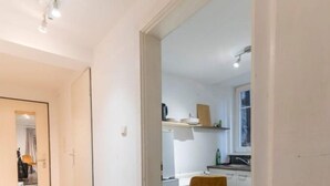 A modern apartment with a hallway leading to a kitchen area.