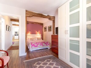 A bedroom with a bed, a dresser, and a wardrobe with frosted glass doors.