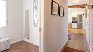 A modern interior with a wooden ceiling, a kitchen area with stainless steel appliances, and a hallway with a patterned rug. - Bright apartment in Mundaka, perfect for couples and families, near the beach (Mundaca)