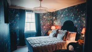 Une chambre à coucher avec un lit, une table de chevet, une lampe et une commode.