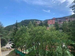 A multi-story building with a modern design, surrounded by dense forest. - Cozy 6 pers apartment, terrace with tennis view, Wifi (Pra-Loup)