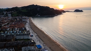 A coastal cityscape with a beach, buildings, and a sunset. - Charming 3-bedroom apartment in Zarautz, close to the beach (Zarauz)