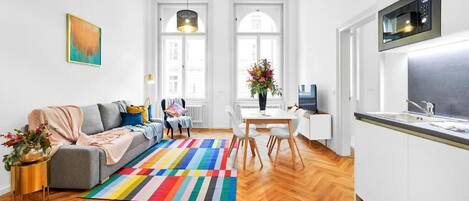 Een modern appartement met een woonkamer, eethoek en keuken.