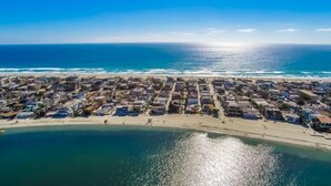 Luchtbeeld van een kustplaatsje met strand en zee.