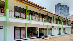 A two-story building with balconies, large windows, and a paved ground. - Hotel O P3 Guest House (Cileunyi)