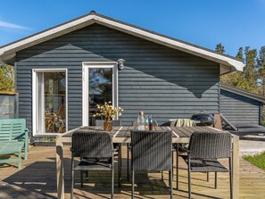 A wooden deck with a table and chairs, a grill, and a bottle of water. - "Antonella" - 400m from the sea by Interhome (Sæby)