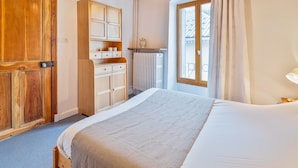 A bedroom with a wooden ceiling, a large bed, a wardrobe, and a window with curtains. - Cozy 1BR Apartment, Balcony, Pool, Close to Serre Chevalier Slopes, Free Wi-Fi & Parking (Saint-Chaffrey)