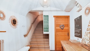 A wooden staircase leading to a room with a heart-shaped decoration on the door, a bench, a table, and a wall with a mirror and a sign. - Cozy 1BR Apartment, Balcony, Pool, Close to Serre Chevalier Slopes, Free Wi-Fi & Parking (Saint-Chaffrey)