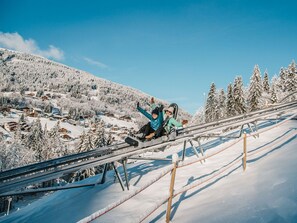 A snowy mountain landscape with a ski lift and wooden cabins. - Spacious 5-Bedroom Apartment in Les Gets with Wi-Fi, Balcony & Near Ski Lifts (Les Gets)