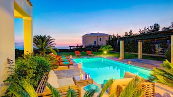 Une piscine avec des chaises longues et une pergola.