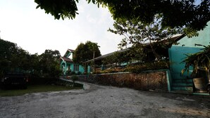 A residential area with a house, a car, and a paved driveway. - OYO 93248 Villa Syariah Astuti Lestari (Parongpong)