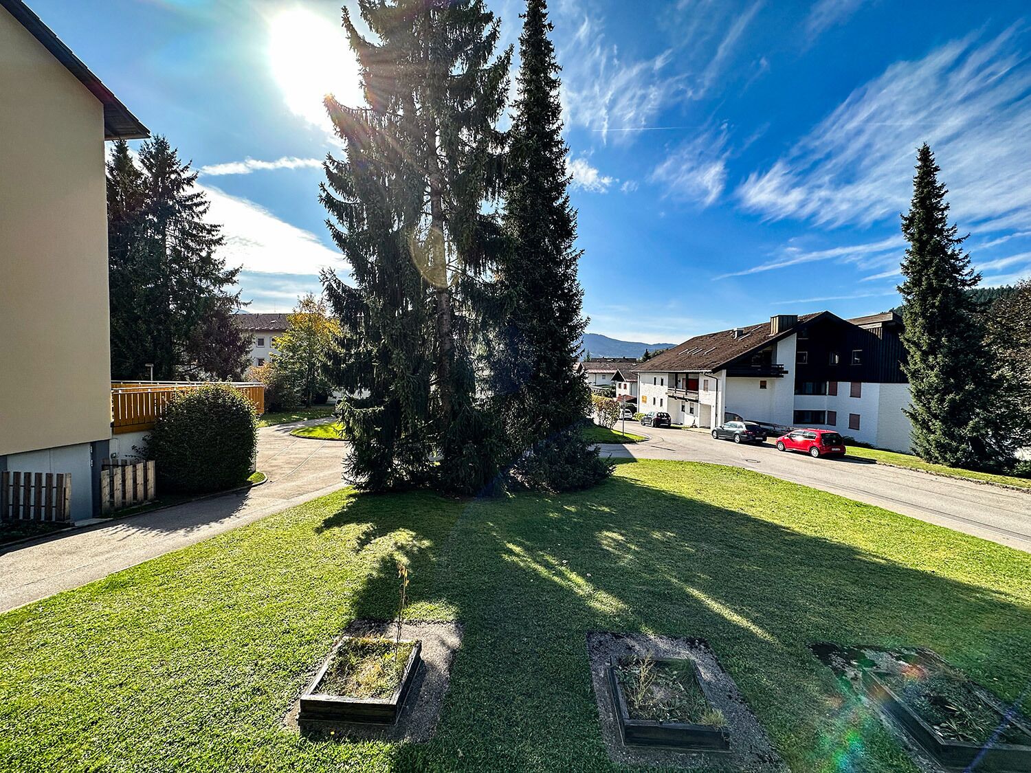 A residential area with houses, a well-maintained lawn, and a clear sky.