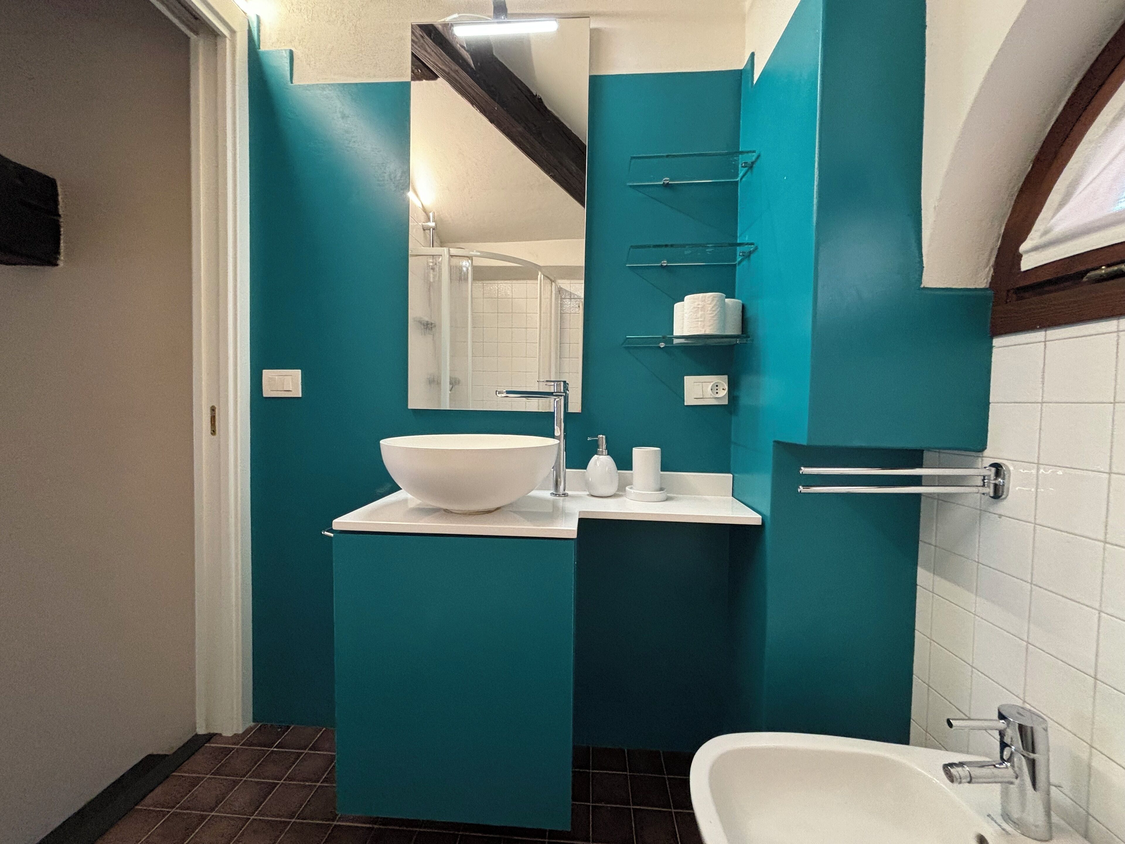 A modern bathroom with a white sink, a mirror, and a bathtub.