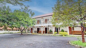 A building with a traditional architectural style, featuring a central courtyard with a paved area and benches.