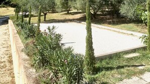 A landscaped area with neatly trimmed hedges and trees, a paved walkway, and a clear blue sky. - Maison Provençale Avec Grande Piscine à Goult en Plein Coeur du Luberon (Goult)