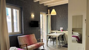 A hotel room with a bed, a chair, a desk, and a television. - LOFT 17 ARENA (Verona)