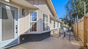 Un immeuble résidentiel doté d’un patio couvert, de fondations en briques et d’une clôture en bois.