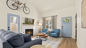 Un salon moderne avec une cheminée, un canapé, une table basse et une porte bleue.