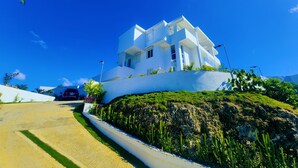 Un bâtiment moderne, de couleur blanche, doté d’un toit plat, d’une allée pavée et d’un espace paysager agrémenté de cactus.