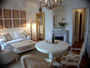 A living room with a white sofa, a coffee table, and a fireplace. - Central Parisian apartment. A 5 minute walk to the Notre-Dame and the Seine (Paris)