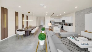 Una cocina moderna con armarios blancos y una salpicadera de mármol.
