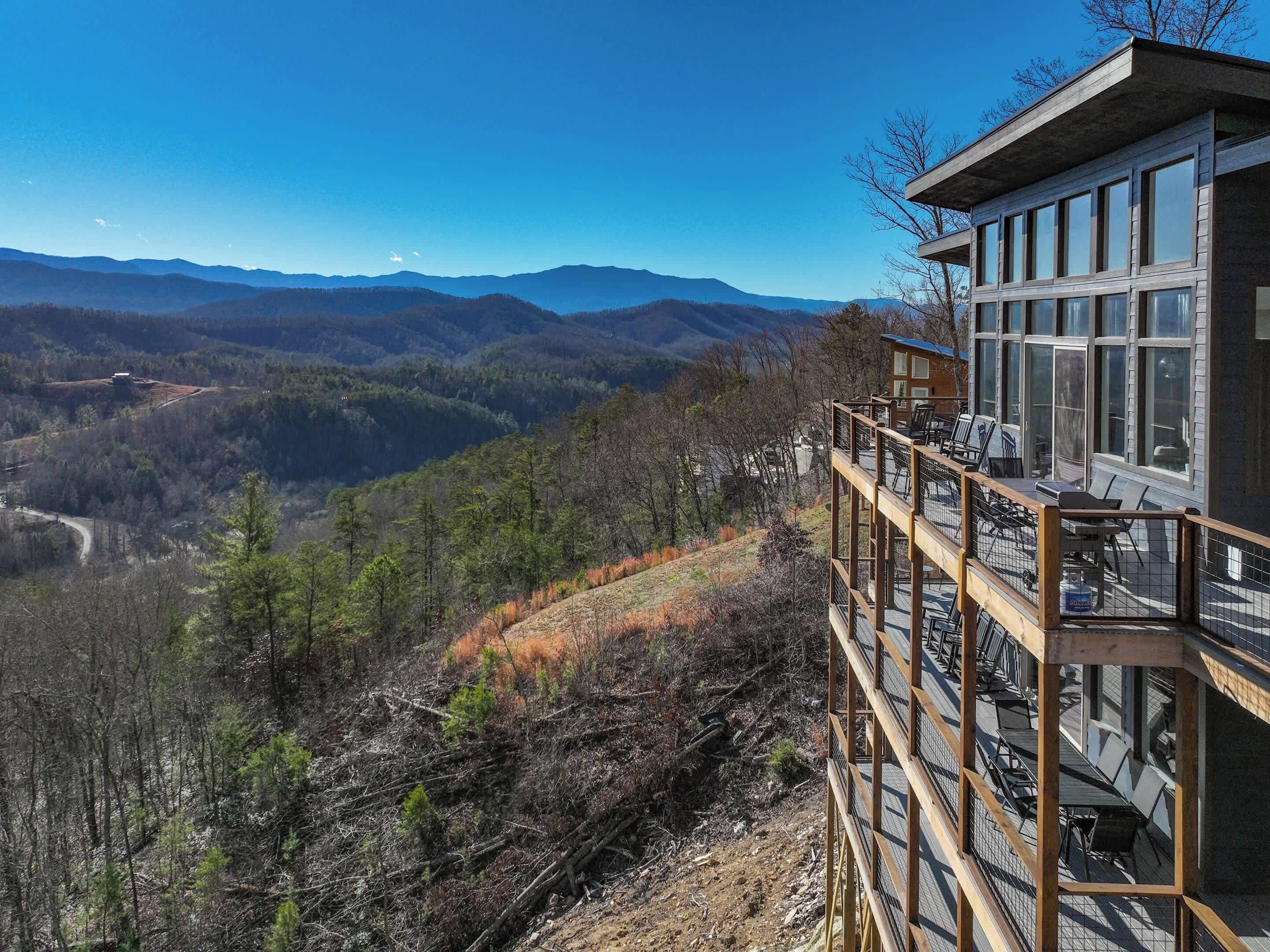 A modern building with a balcony overlooking a mountainous landscape.