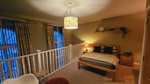 A bedroom with a bed, a chair, a small table, a lamp, and a window with curtains. - Charming 1-bed Apartment in Newark (Newark)