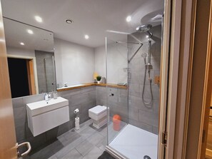 A modern bathroom with a glass-enclosed shower, a white sink, and a toilet. - Charming 1-bed Apartment in Newark (Newark)