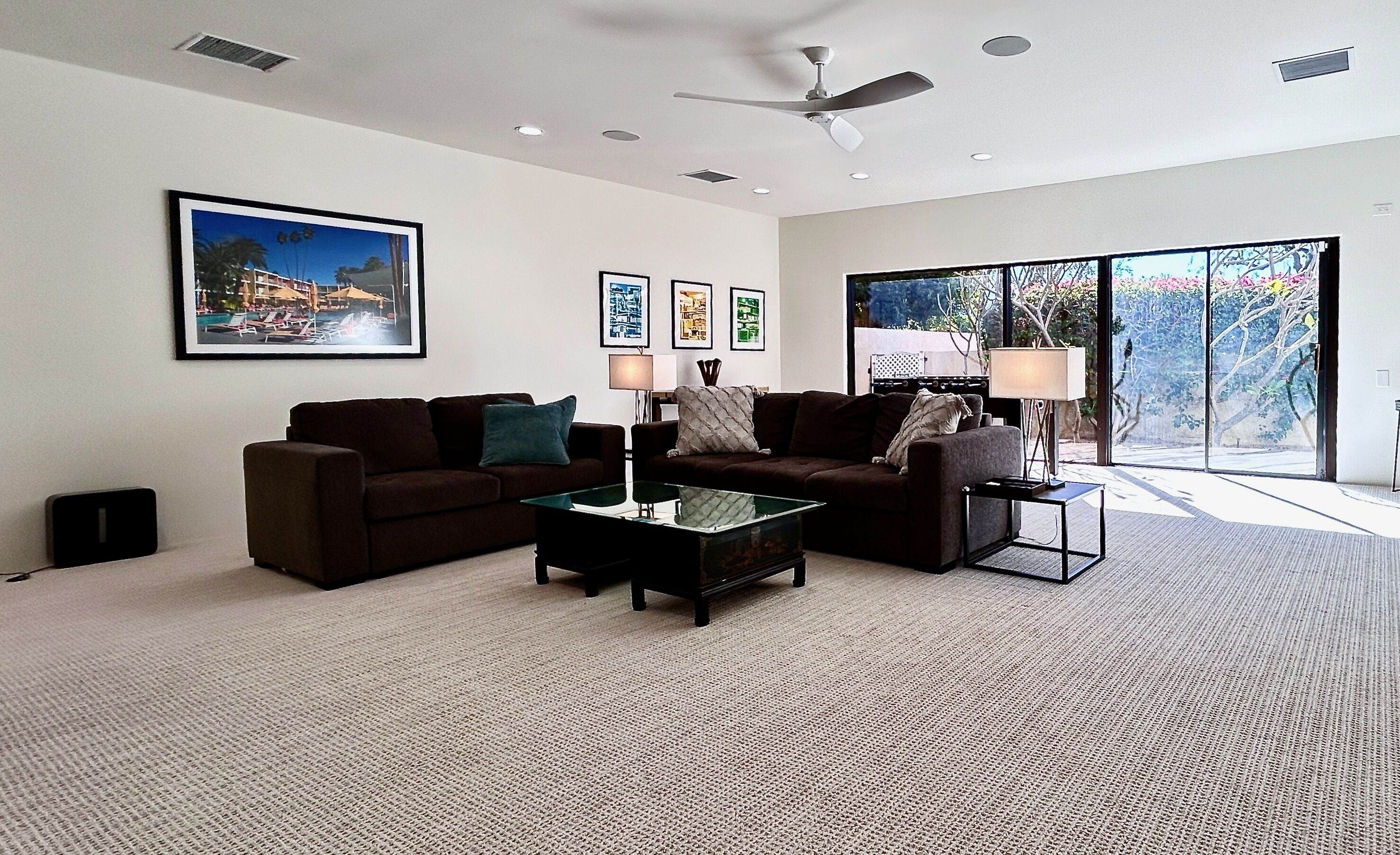 A modern living room with a sofa, coffee table, and a ceiling fan.