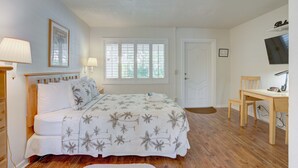 Quarto com uma cama, uma mesa e uma cadeira.