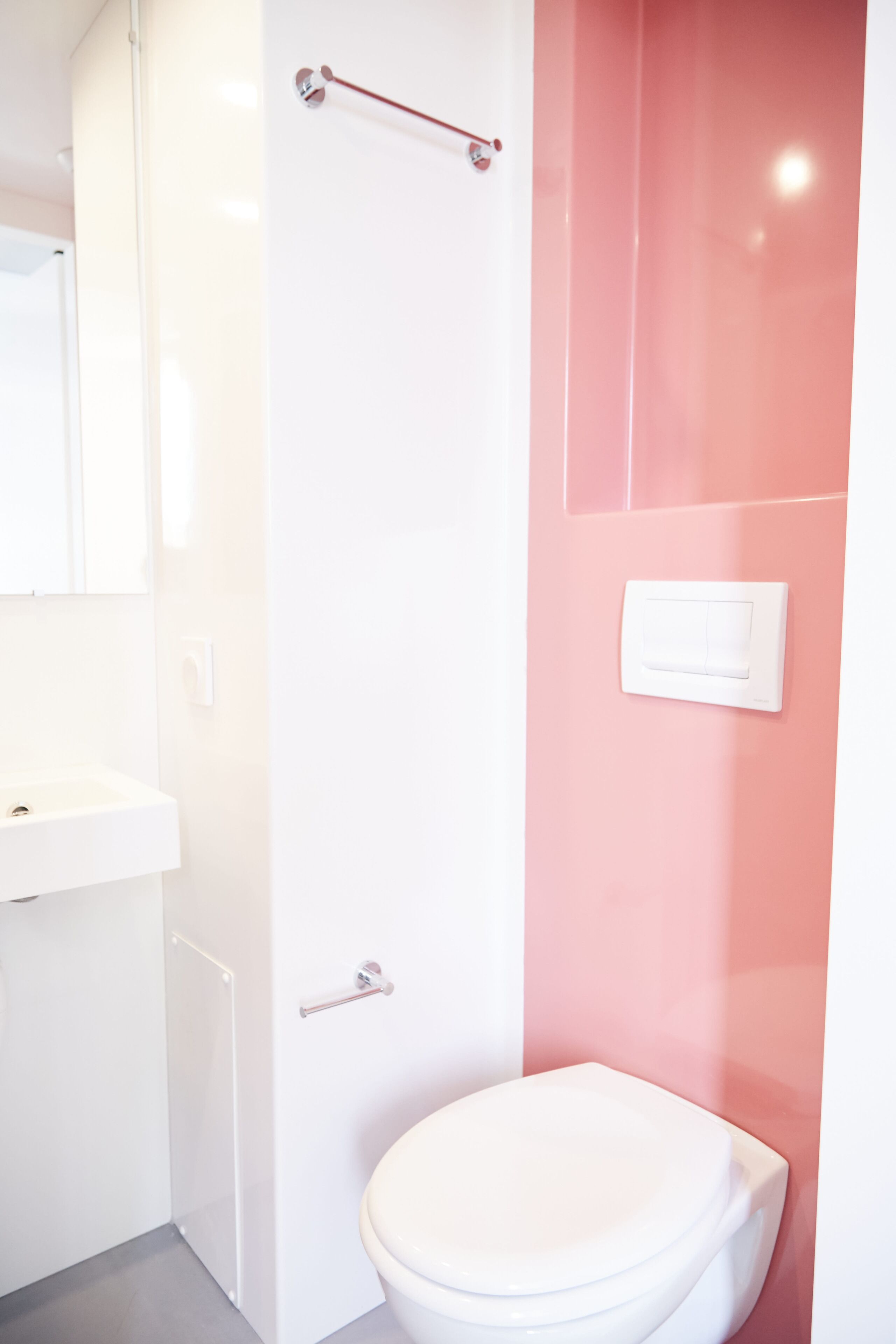 Un baño con inodoro y lavamanos blancos, y una zona de ducha.