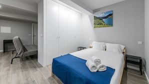 A bedroom with a bed, a desk, a chair, and a wardrobe. - GuestReady - Olivieri's House - 1 (Porto)