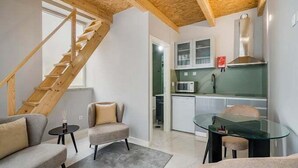 A modern interior with a staircase, a kitchen, and seating area.