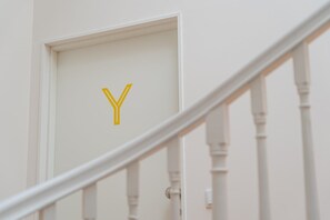 Staircase leads to an upper level, featuring a door with a distinctive 'Y' symbol.