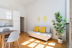 Cozy living space with a dining table, sofa, and potted plant.