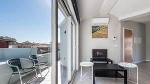 A modern apartment with a balcony, a dining area, and a TV.