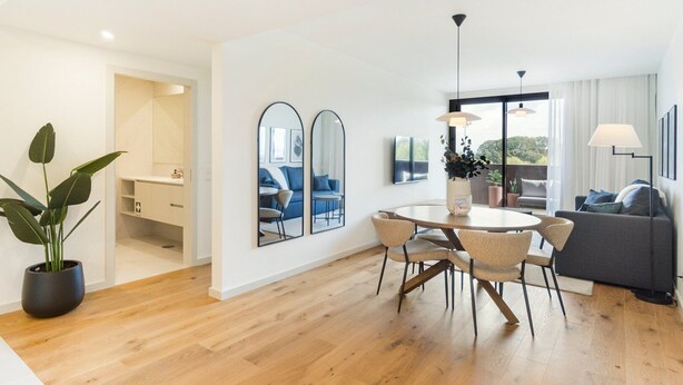 A modern living room with a dining area, large mirrors, and a potted plant. - GuestReady - Asaf's Magnolias Retreat (Vila Nova de Gaia)