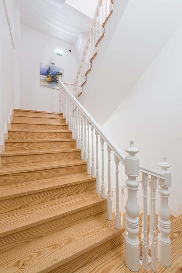 A wooden staircase with white balusters leading to a landing.