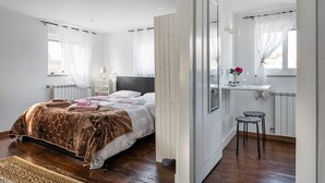 A bedroom with a bed, bedside table, and a small stool. - Garden-inspired retreat (Celeiros)