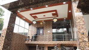 A building with a brick facade, a balcony with a metal railing, and a large window. - Shri Laddu Gopal Guest House (Mathura)