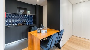 Una cocina moderna con microondas integrado, cafetera y una botella de vino sobre la encimera.