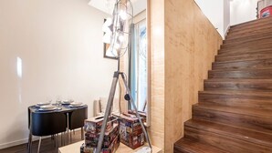 A staircase with wooden steps, a dining area with a table and chairs, and a ladder with boxes labeled 'Route 66'.