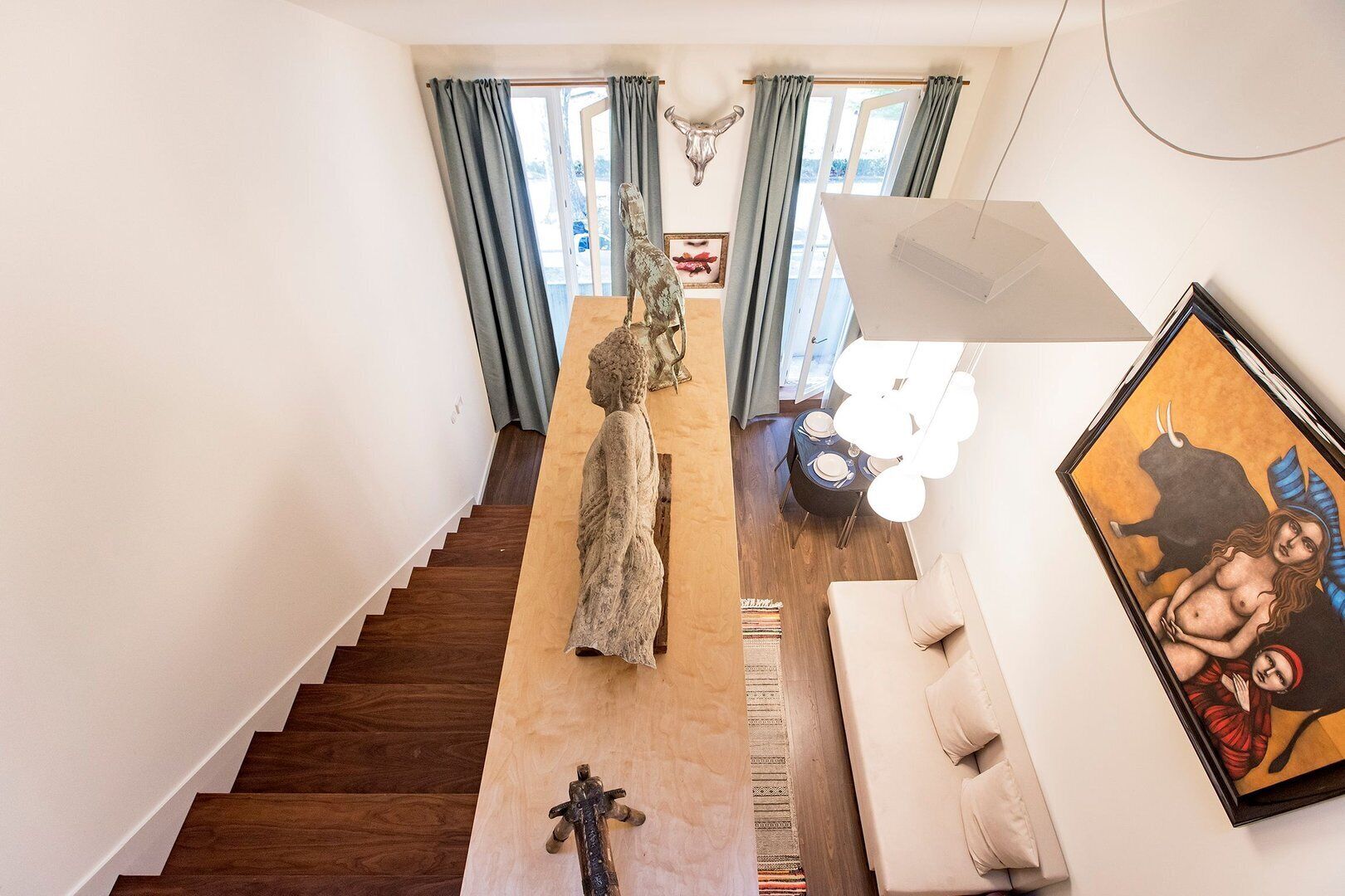 A modern interior with a staircase, a dining area, and a living space.
