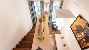 A modern interior with a staircase, a dining area, and a living space.
