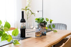 Ein Holztisch mit einer Weinflasche, zwei Gläsern und einer Stadtkarte von Porto.