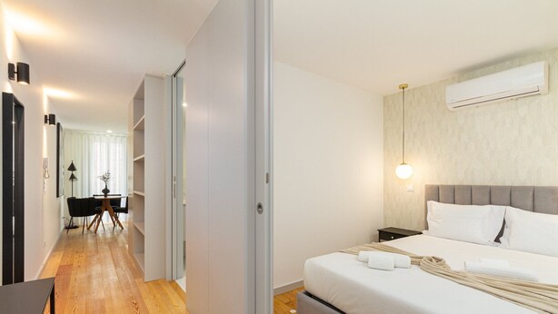 Ein modernes Hotelzimmer mit Bett, Nachttisch und Klimaanlage.