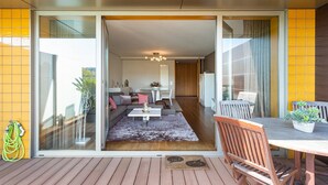 Ein modernes Wohnzimmer mit Sofa, Couchtisch und einem Essbereich mit Tisch und Stühlen.