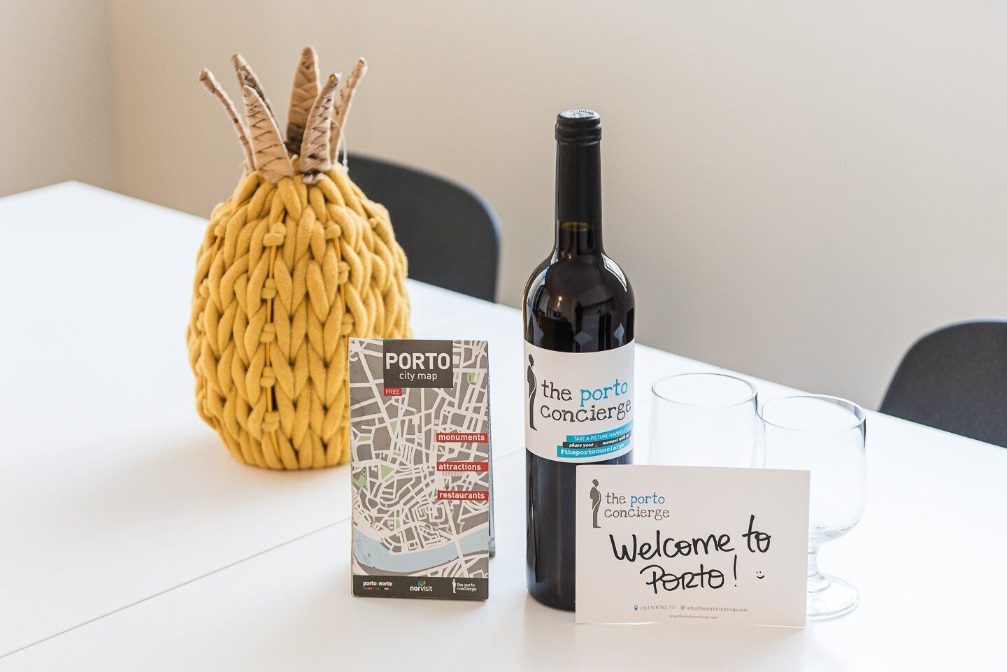 A welcome sign, a bottle of wine, a city map, and a decorative item on a table.
