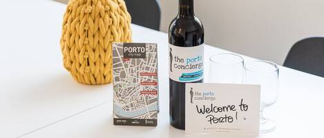 A welcome sign, a bottle of wine, a city map, and a decorative item on a table.
